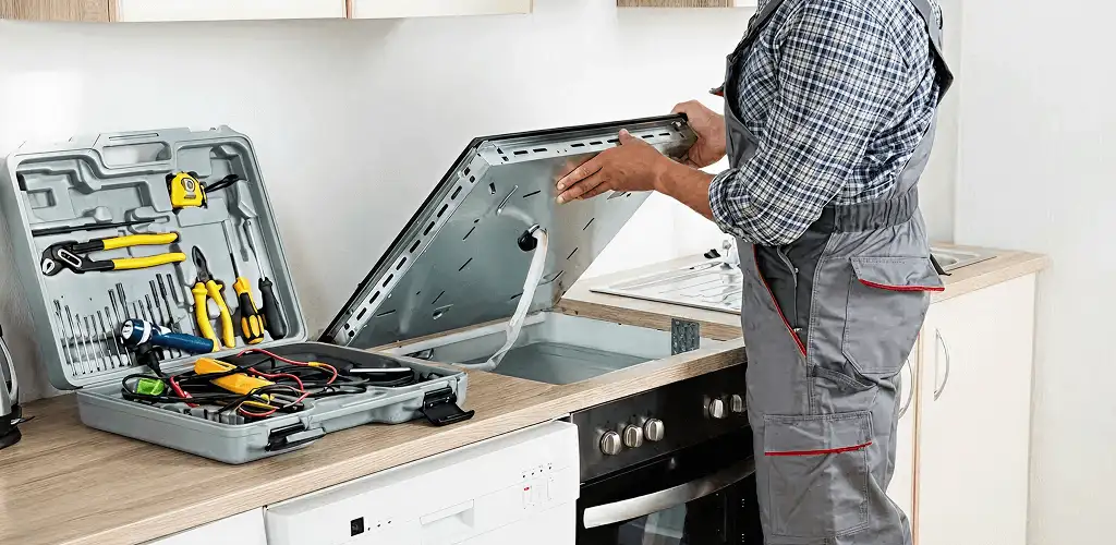 Handyman repairing a cooktop and checking wiring connections in Aurora, IL