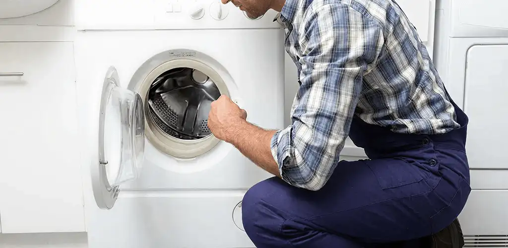 Handyman inspecting a dryer drum and internal parts for repair in Aurora, IL