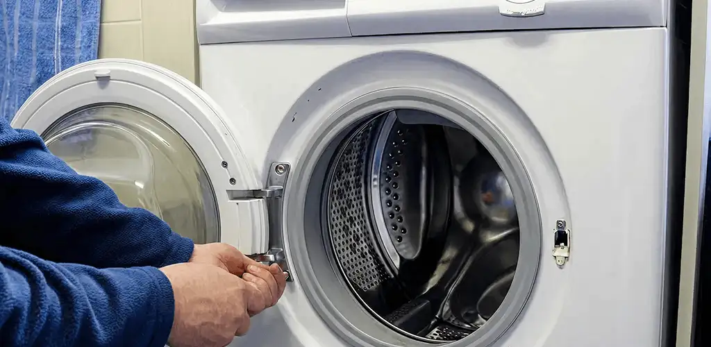 Washing machine repair handyman checking a front-load washer door and latch in Aurora, IL