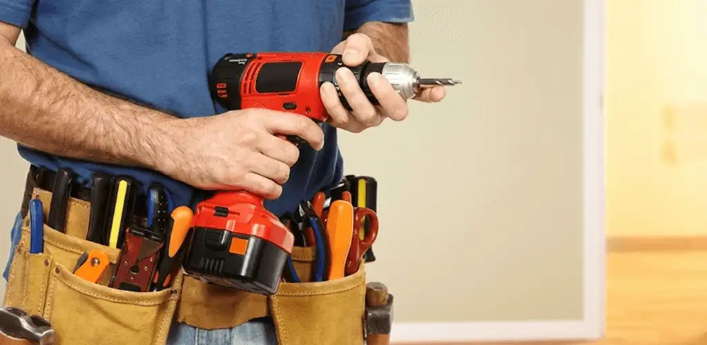 Handyman holding a power drill for home repairs and installations in Aurora, IL