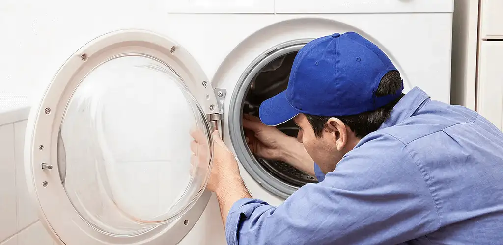 Washing machine repair handyman inspecting a front-load washer drum in Aurora, IL